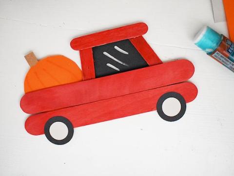 Red truck out of popsicle sticks with pumpkin